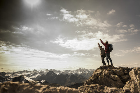 Deutschland, Bayern, Oberstdorf, zwei Wanderer jubeln am Felsen in alpiner Kulisse, lizenzfreies Stockfoto