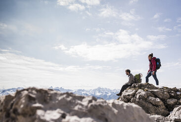 Germany, Bavaria, Oberstdorf, two hikers on rock in alpine scenery - UUF12161