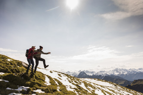 Germany, Bavaria, Oberstdorf, two hikers jumping on alpine meadow stock photo