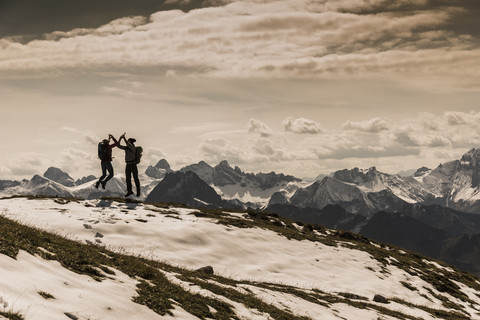 Deutschland, Bayern, Oberstdorf, zwei Wanderer springen in alpiner Landschaft, lizenzfreies Stockfoto