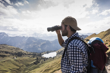 Deutschland, Bayern, Oberstdorf, Wanderer mit Fernglas in alpiner Kulisse - UUF12174