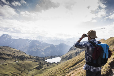 Deutschland, Bayern, Oberstdorf, Wanderer mit Fernglas in alpiner Kulisse - UUF12175