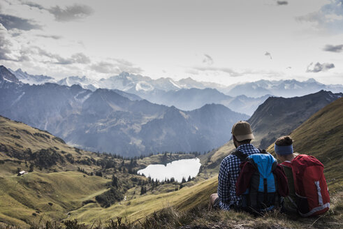 Deutschland, Bayern, Oberstdorf, zwei Wanderer in alpiner Kulisse sitzend - UUF12177