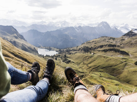 Deutschland, Bayern, Oberstdorf, Beine zweier Wanderer beim Ausruhen in alpiner Kulisse - UUF12182