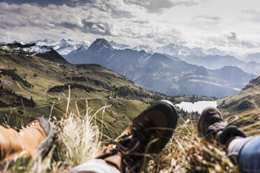 Deutschland, Bayern, Oberstdorf, Füße von zwei Wanderern, die sich in alpiner Landschaft ausruhen - UUF12184