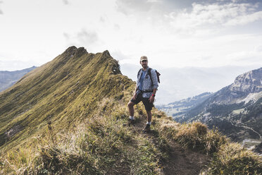 Germany, Bavaria, Oberstdorf, hiker standing on mountain ridge in alpine scenery - UUF12190