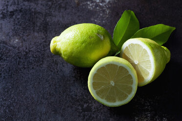 Green organic lemons on dark background - CSF28469