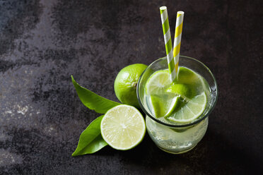 Fruchtschorle mit Limetten in einem Glas mit Trinkhalmen - CSF28480