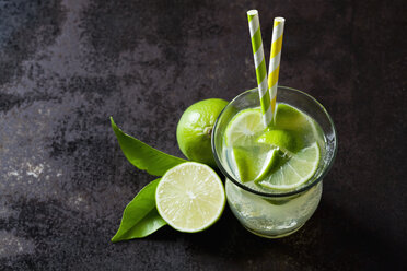 Fruit spritzer of limes in a glass with drinking straws - CSF28480