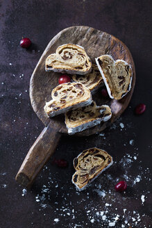 Geschnittener Christstollen mit Puderzucker auf einer Holzkugel - CSF28496