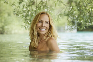 Porträt einer lachenden blonden Frau beim Baden im See - PNEF00228