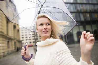Frau mit Regenschirm an einem regnerischen Tag - PNEF00235