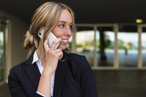 Porträt einer lächelnden Geschäftsfrau am Telefon, lizenzfreies Stockfoto