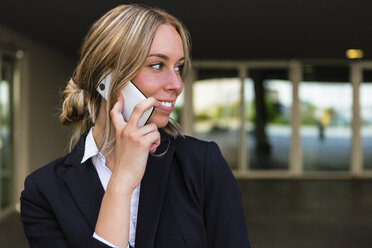 Porträt einer lächelnden Geschäftsfrau am Telefon - MGIF00181