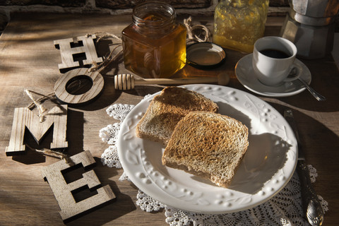 Frühstückstisch mit Toast, Orangenmarmelade, Honig und Espresso, lizenzfreies Stockfoto