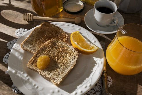 Frühstückstisch mit Toast, Orangenmarmelade, Honig, Orangensaft und Espresso - CSTF01438