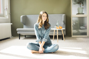 Young woman sitting on the floor in the living room - MOEF00196