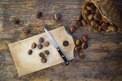Sweet chestnuts in basket and on chopping board, knife - LVF06359