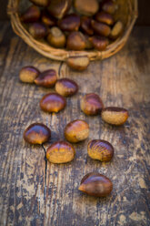 Roasted sweet chestnuts in a basket and on wood - LVF06360