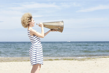Junge Frau mit Megaphon am Strand - TSFF00166