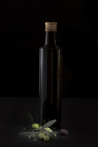 Olive oil bottle and twig with fresh olives stock photo