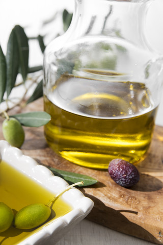 Fresh olive oil in bowl and olives stock photo