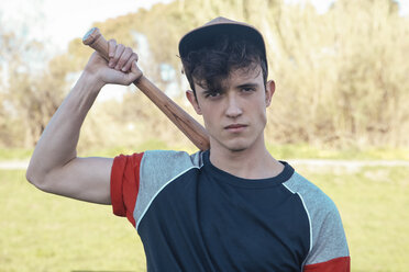 Porträt eines jungen Mannes mit Baseballschläger im Park - RTBF01077