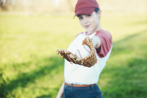 Portrait of young woman with ball and baseball glove stock photo