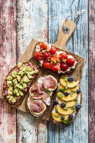 Verschiedene Sandwiches, Erdbeere, Feige, Nektarine, Avocado, auf Schneidebrett, lizenzfreies Stockfoto