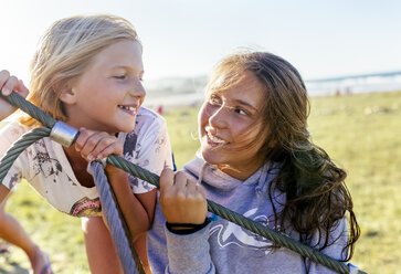 Two happy girls looking at each other - MGOF03659