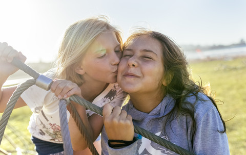 Mädchen küsst ihre ältere Schwester, lizenzfreies Stockfoto