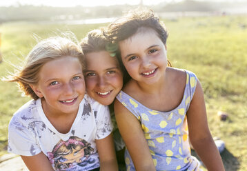 Gruppenbild von drei Mädchen Kopf an Kopf im Sommer - MGOF03661