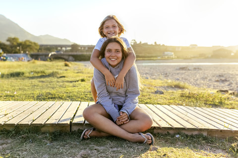 Portrait of two smiling girls on boardwalk stock photo