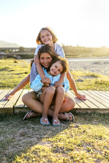 Gruppenbild von drei glücklichen Mädchen auf der Strandpromenade - MGOF03668