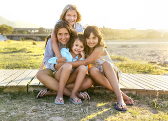 Group picture of four girls sitting on boardwalk in summer - MGOF03669