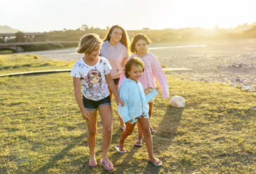 Four girls playing outdoors at sunset girls on boardwalk - MGOF03674
