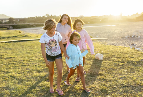 Vier Mädchen spielen im Freien bei Sonnenuntergang Mädchen an der Strandpromenade - MGOF03674