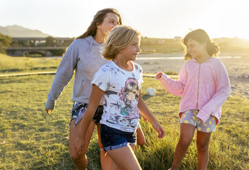 Four girls playing outdoors at sunset girls on boardwalk - MGOF03675