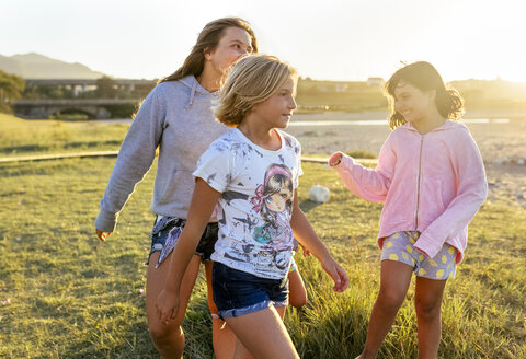 Vier Mädchen spielen im Freien bei Sonnenuntergang Mädchen an der Strandpromenade - MGOF03675