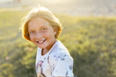 Porträt eines glücklichen blonden Mädchens im Gegenlicht - MGOF03679