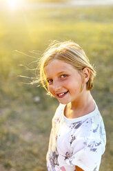 Porträt eines lächelnden blonden Mädchens im Gegenlicht - MGOF03686