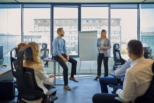 Businesswoman leading a presentation at flip chart in office - ZEDF00940