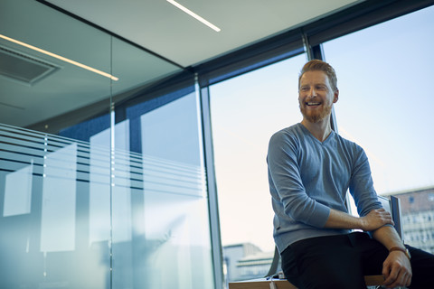 Glücklicher Geschäftsmann im Büro, lizenzfreies Stockfoto