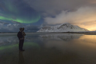 Norwegen, Lofoten, Vareid, Flakstad, Mann beobachtet Sonnenuntergang und Nordlicht - RPSF00040