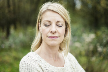 Portrait of blond woman with eyes closed outdoors - MOEF00248