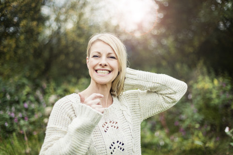 Porträt einer glücklichen blonden Frau im Freien, lizenzfreies Stockfoto