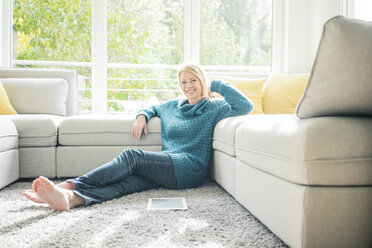 Portrait of smiling woman relaxing in living room - MOEF00275