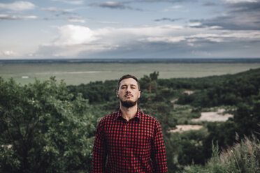 Man with closed eyes in rural landscape - VPIF00233