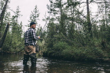 Angler mit Wathose im Fluss stehend - VPIF00239