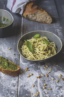 Hausgemachtes Basilikum-Pesto, Spaghetti in einer Schüssel, Roggenbaguette auf Holz - ODF01561